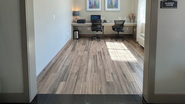 A modern office space with a desk, two chairs, a computer, and artwork on the wall. - Best Western Cleveland Inn & Suites (Cleveland)