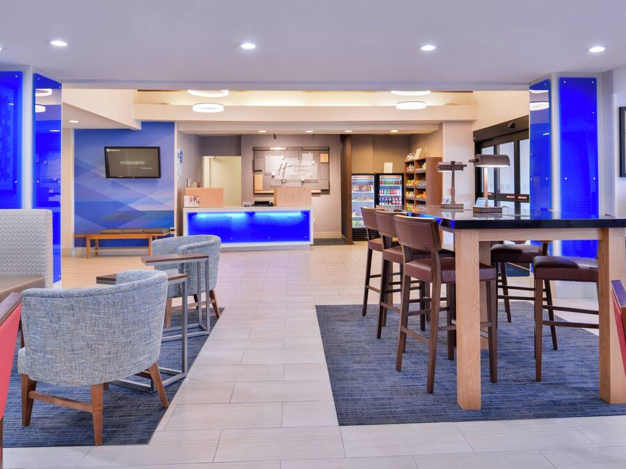 A hotel lobby with seating areas, a reception desk, and a minibar.