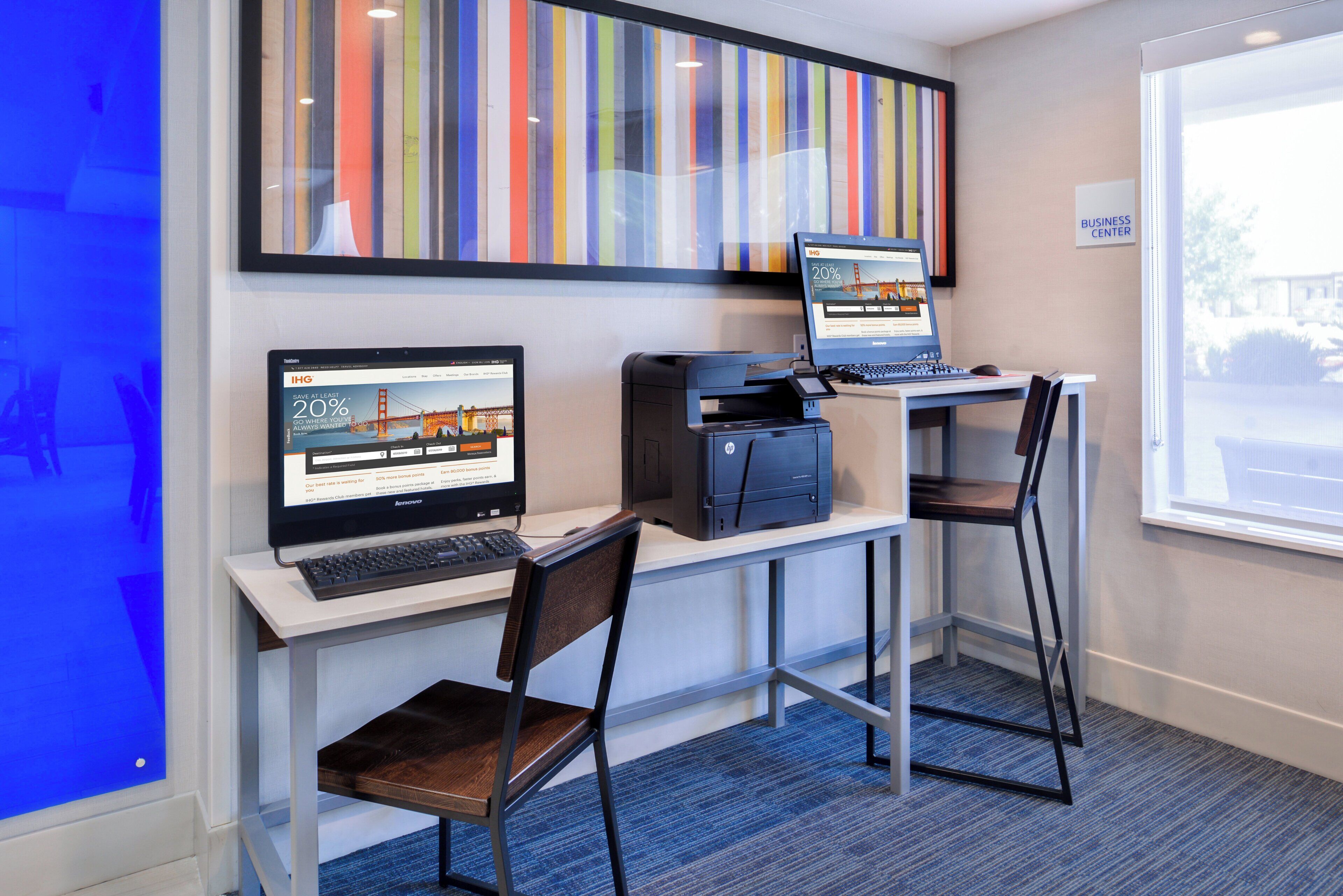 A workspace with two laptops, a desktop computer, and a printer on a desk.