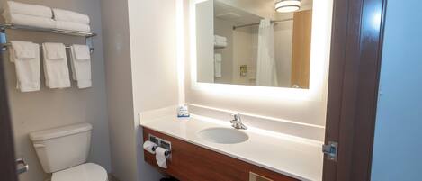 A bathroom with a toilet, a sink, a mirror, and a towel rack.