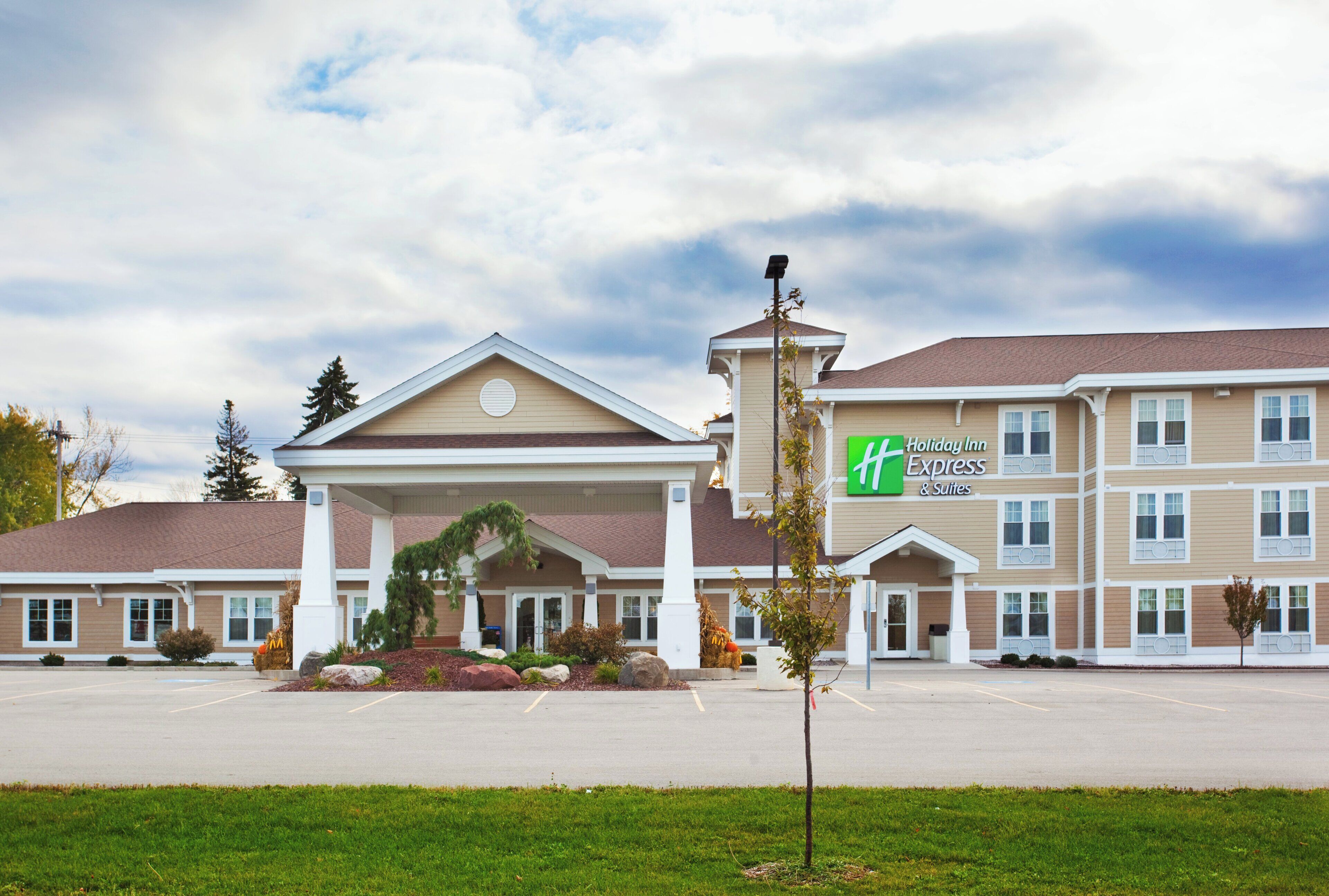 A Holiday Inn Express & Suites hotel with a central entrance, multiple floors, and a parking lot.