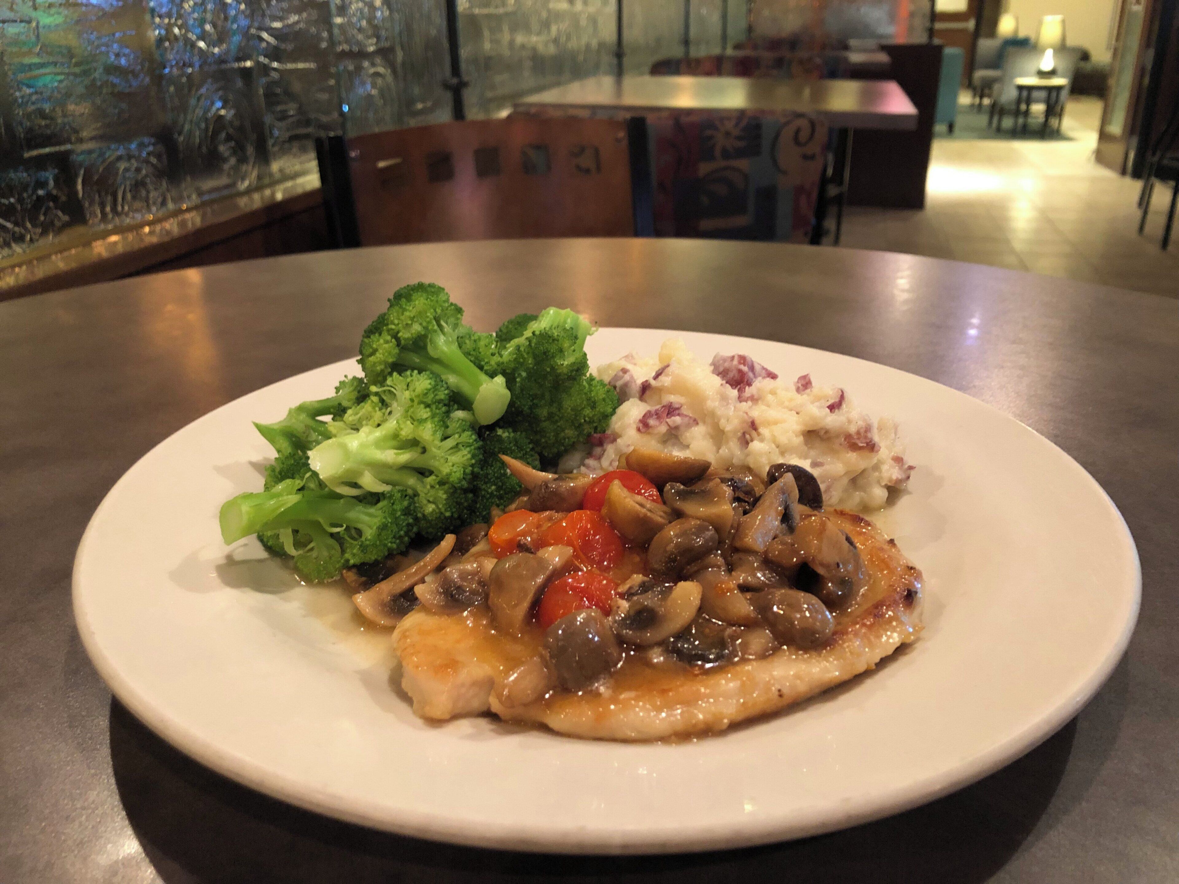A plate with chicken, broccoli, and mashed potatoes.