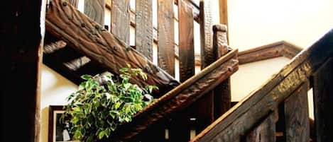 A wooden staircase with a plant on the landing.