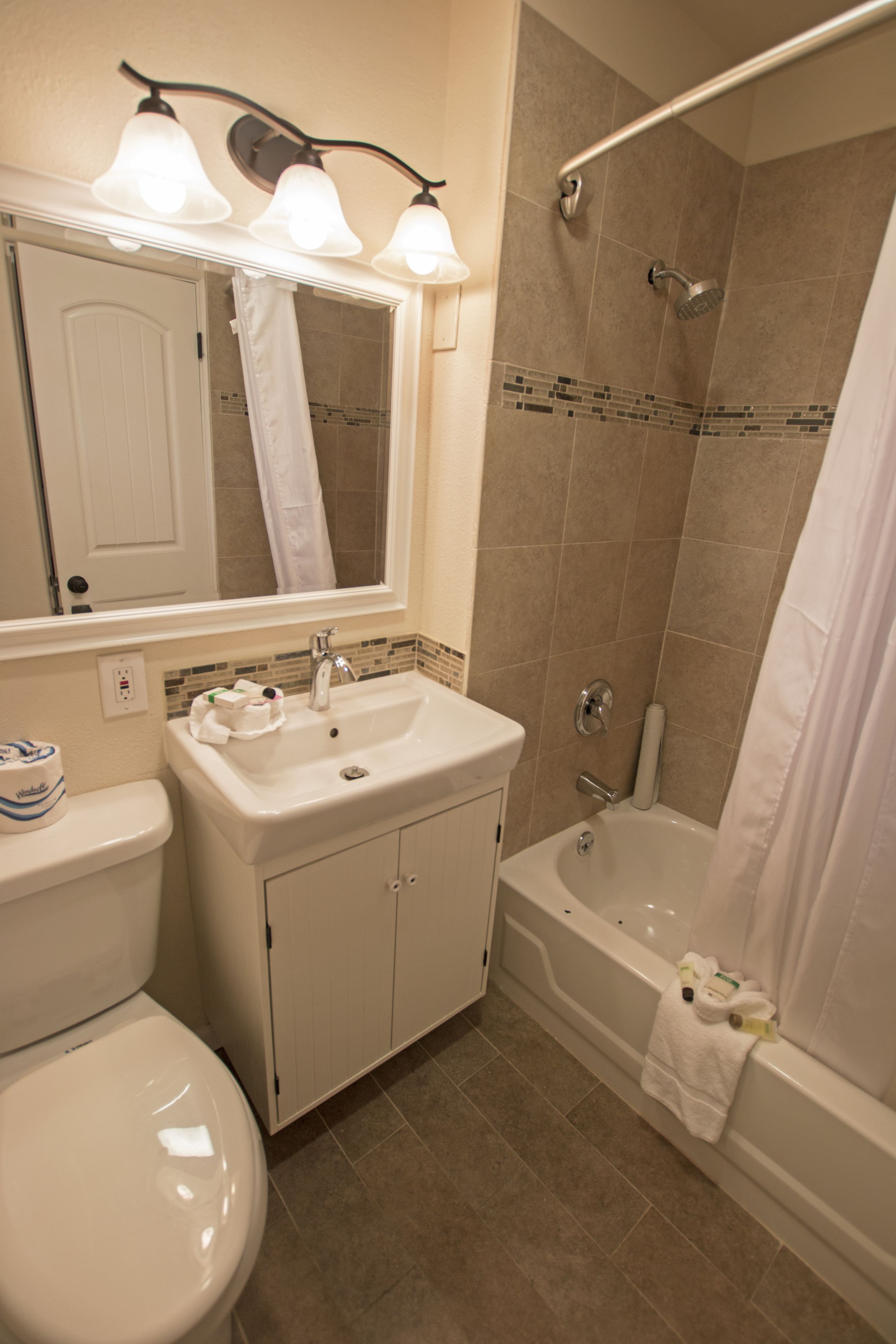 A bathroom with a toilet, sink, and bathtub.