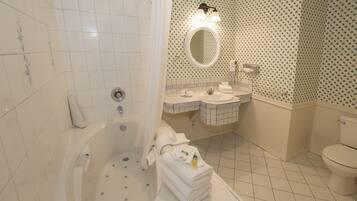 A bathroom with a bathtub, a sink, a toilet, and a mirror.
