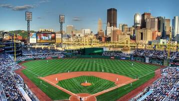Un estadio de béisbol con una amplia zona de asientos, un campo de juego y un horizonte urbano al fondo.