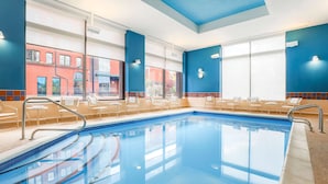 A swimming pool with chairs and a view of a red brick building. - Hampton Inn & Suites Pittsburgh-Downtown (Pittsburgh)