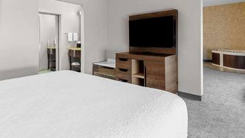 A modern hotel room with a large bed, a wooden TV stand, a bathroom with a bathtub, and a separate shower area.