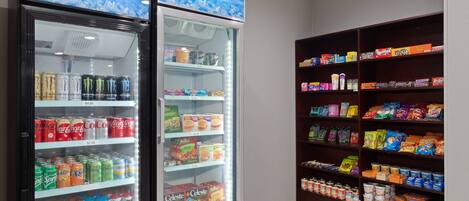 A vending machine with various snacks and drinks, and a shelf stocked with packaged goods.