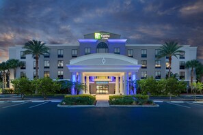 Un hotel Holiday Inn Express con fachada moderna, amplios ventanales y una entrada bien iluminada.