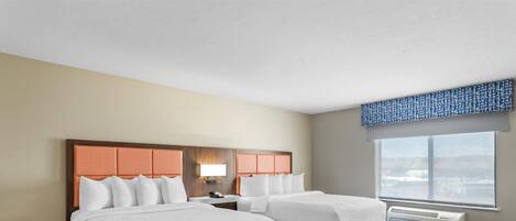 Habitación de hotel con dos camas, un ventanal con vistas, ventilador de techo y un calentador de pared.