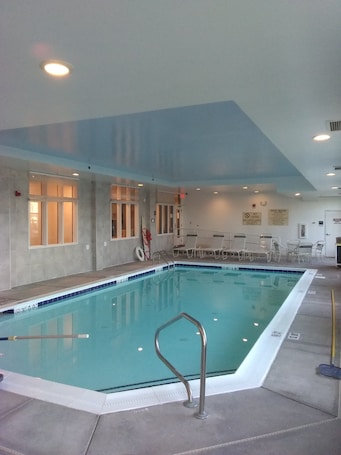 Una piscina techada, sillones reclinables de piscina