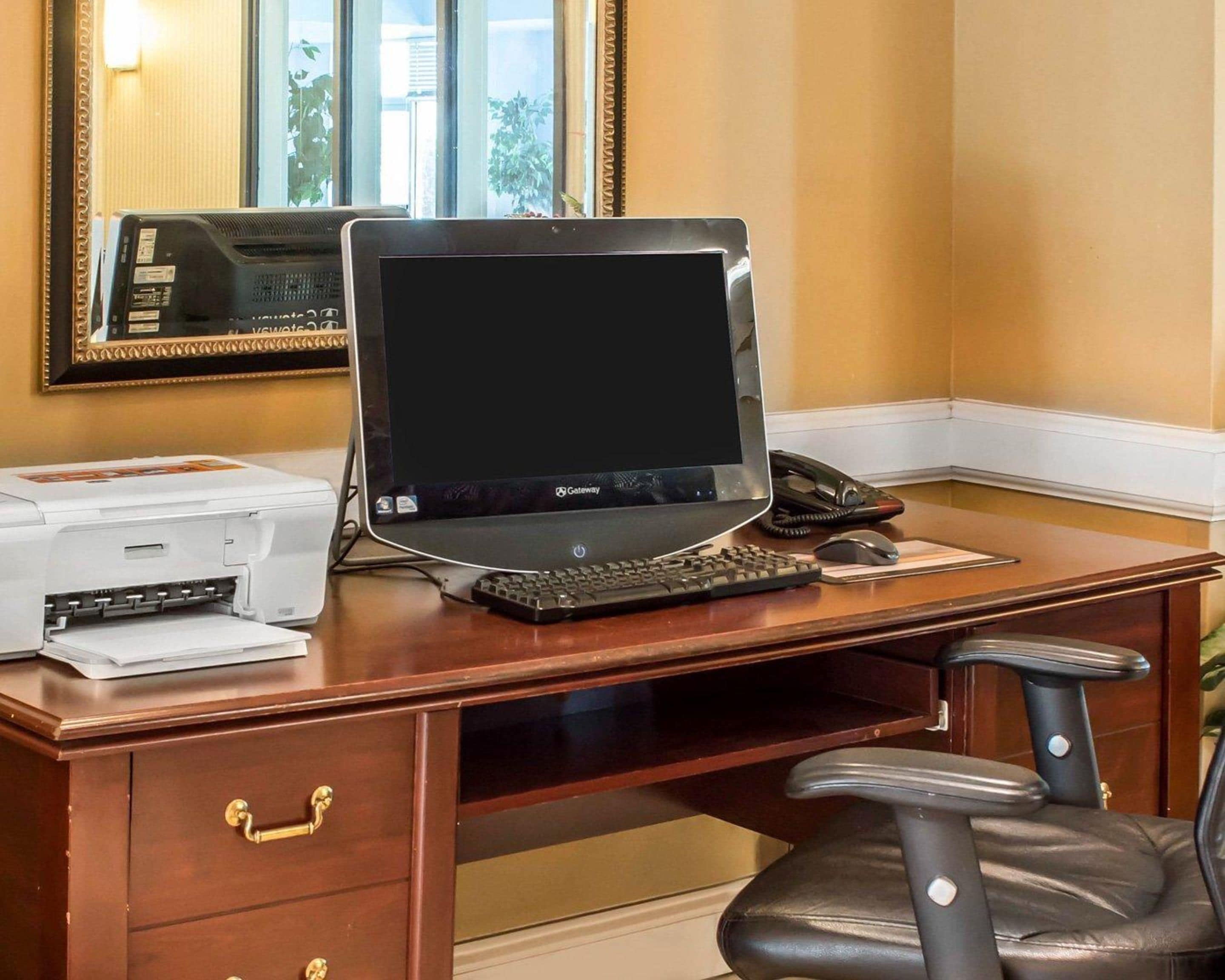 A wooden desk with a Gateway laptop, a printer, and a telephone.