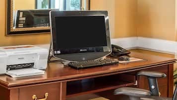 Ein Holztisch mit einem Gateway Laptop, einem Drucker und einem Telefon.