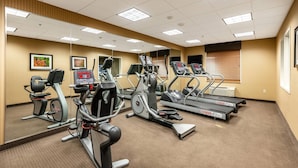 Un gimnasio con cintas de correr, elípticas y bicicletas estáticas.