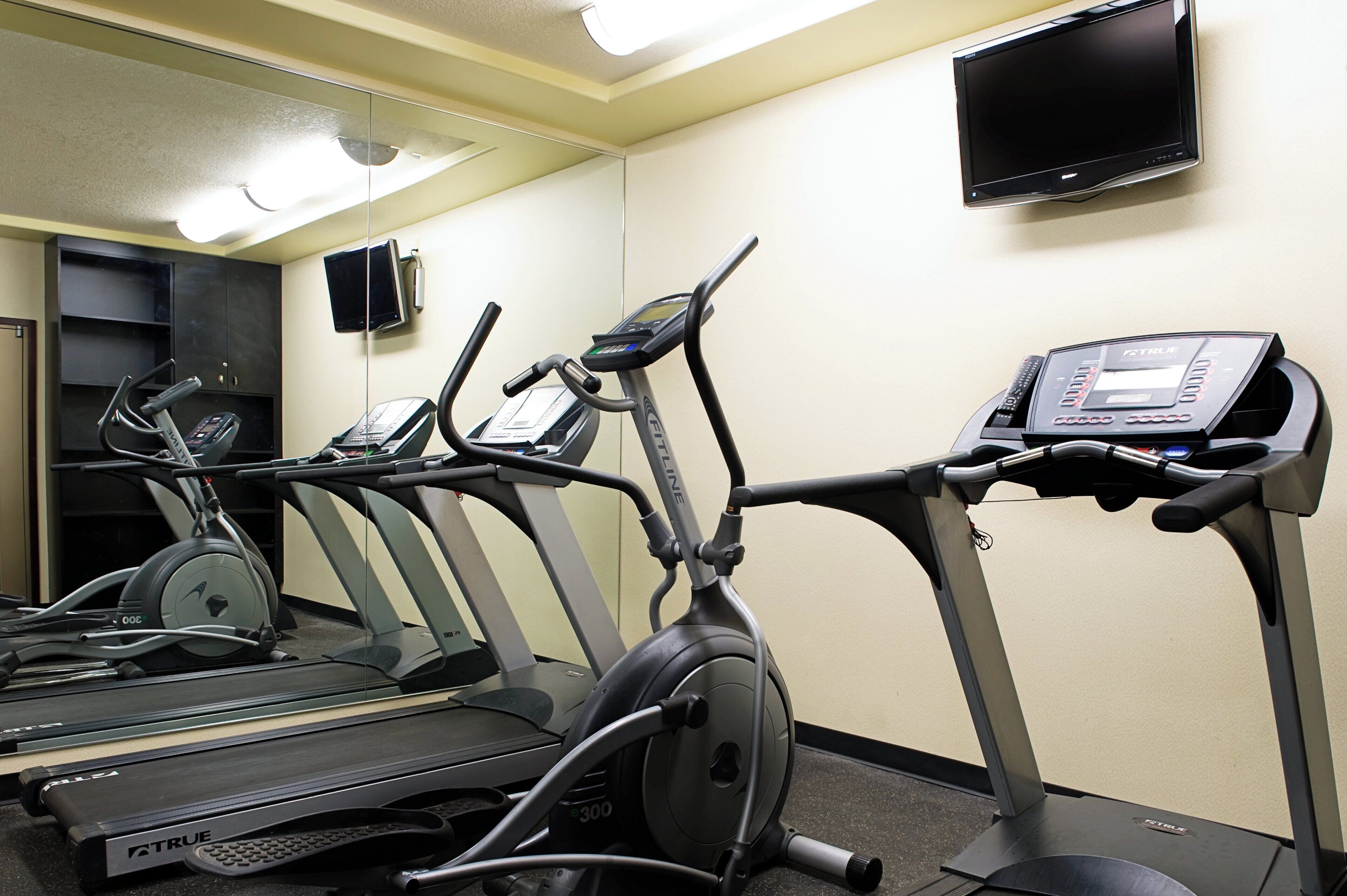 A gym with treadmills, a stationary bike, and a weight bench.