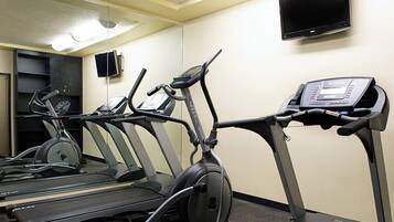 A gym with treadmills, a stationary bike, and a weight bench.