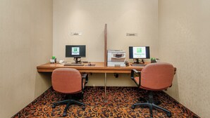 A hotel room with a desk, two chairs, a printer, and two monitors. - Holiday Inn Hotel & Suites Lloydminster by IHG (Lloydminster)