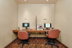 A hotel room with a desk, two chairs, a printer, and two monitors. - Holiday Inn Hotel & Suites Lloydminster by IHG (Lloydminster)