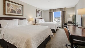 A hotel room with two beds, a desk, a chair, a television, and a window with curtains. - Holiday Inn Hotel & Suites Lloydminster by IHG (Lloydminster)