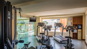 Un gimnasio con cintas de correr, elípticas y máquinas de pesas.