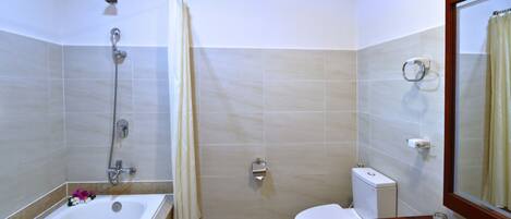 A bathroom with a bathtub, toilet, and sink.