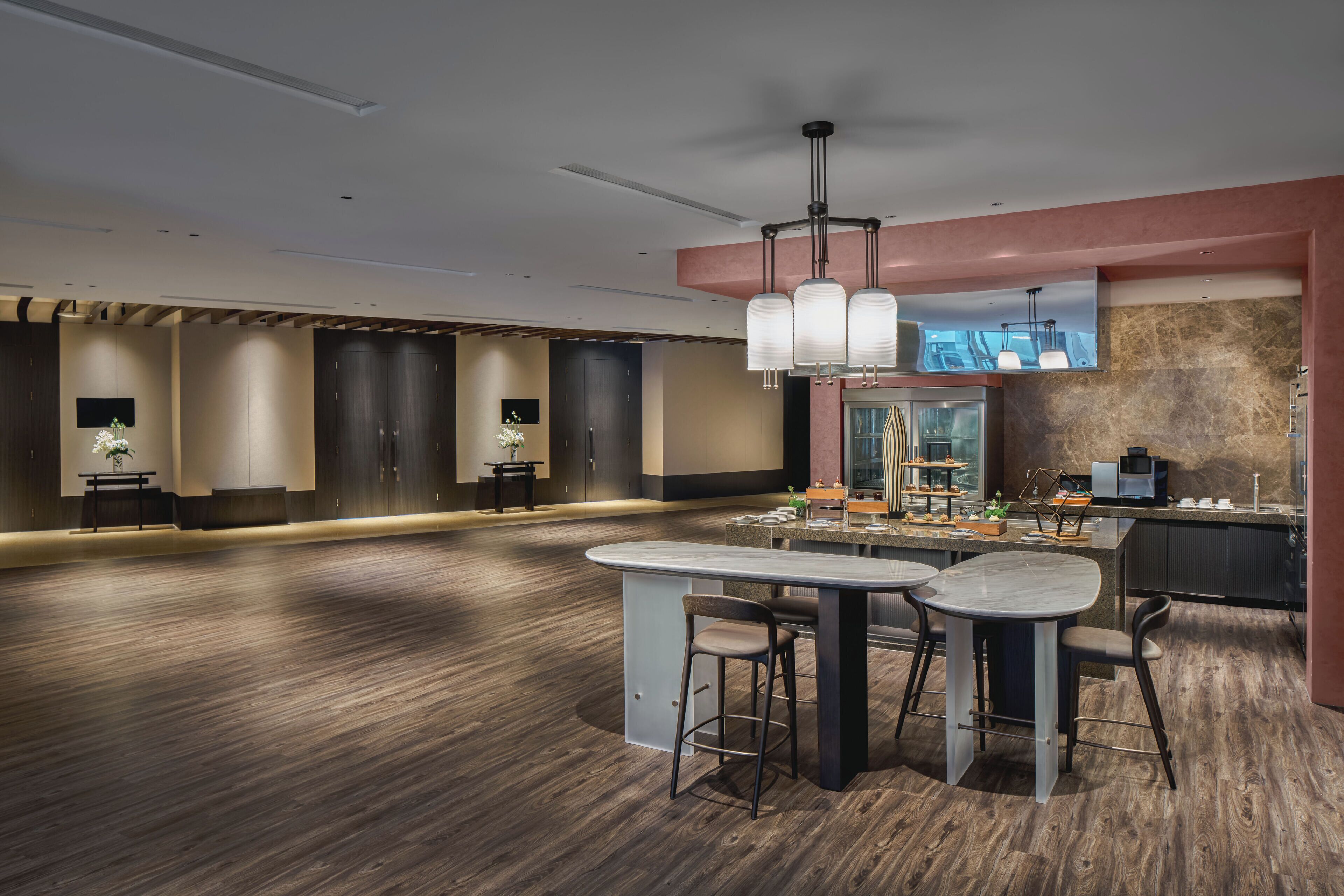 Una cocina moderna con una isla central, taburetes de bar e iluminación colgante.