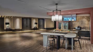 Una cocina moderna con una isla central, taburetes de bar e iluminación colgante.