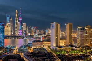 A cityscape with modern skyscrapers, a prominent tower with a spherical observation deck, and a river in the foreground. - Hyatt on the Bund, Shanghai (Shanghai)