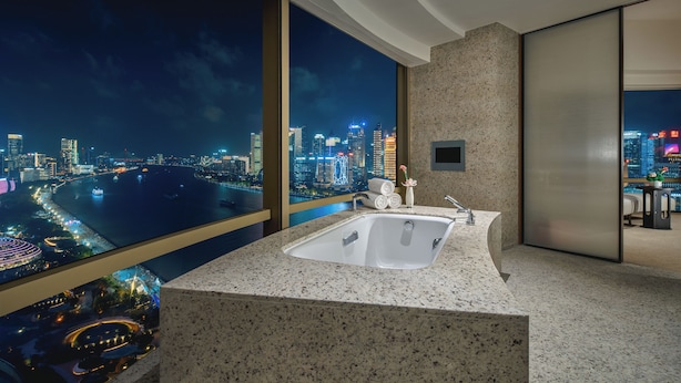 A modern bathroom with a large sink, a mirror, and a view of a cityscape at night. - Hyatt on the Bund, Shanghai (Shanghai)