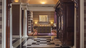A hotel lobby with a checkered floor, a patterned sofa, and a large framed artwork on the wall. - The Roseate Reading (Reading)