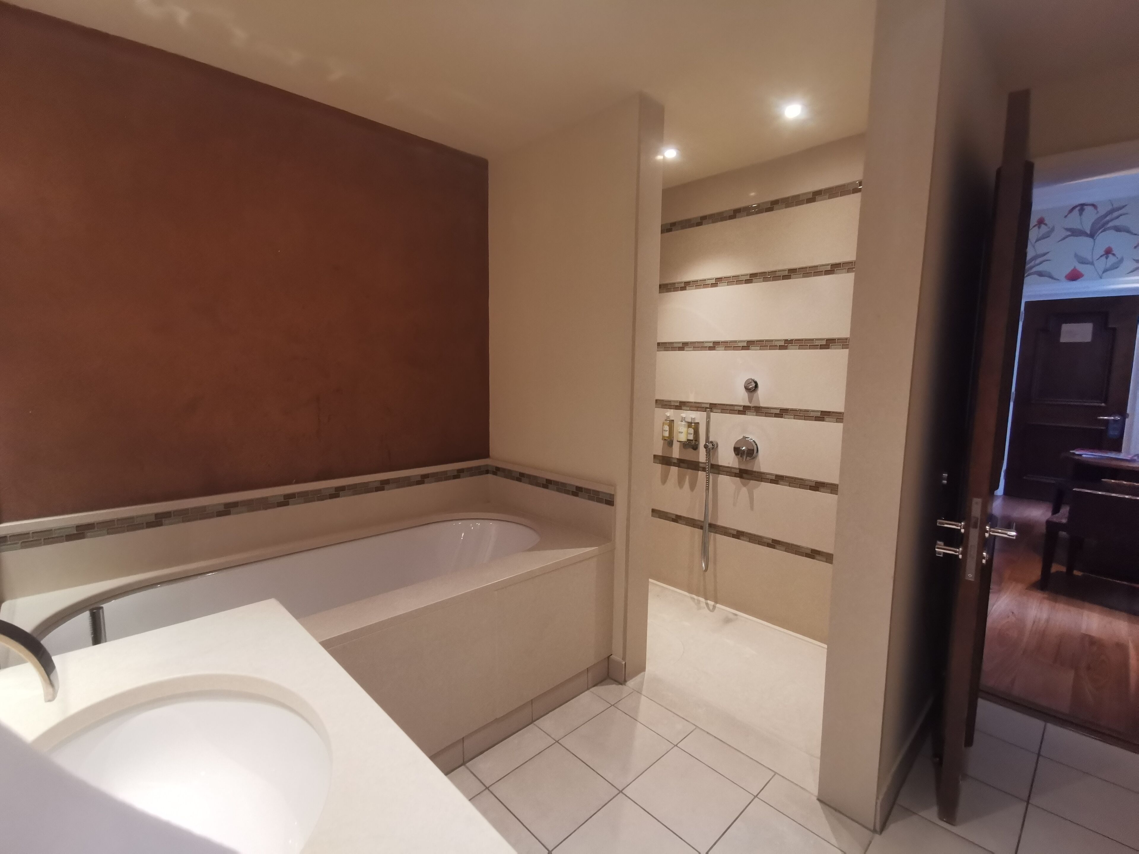 A modern bathroom with a large bathtub, a shower, and a vanity with a mirror.