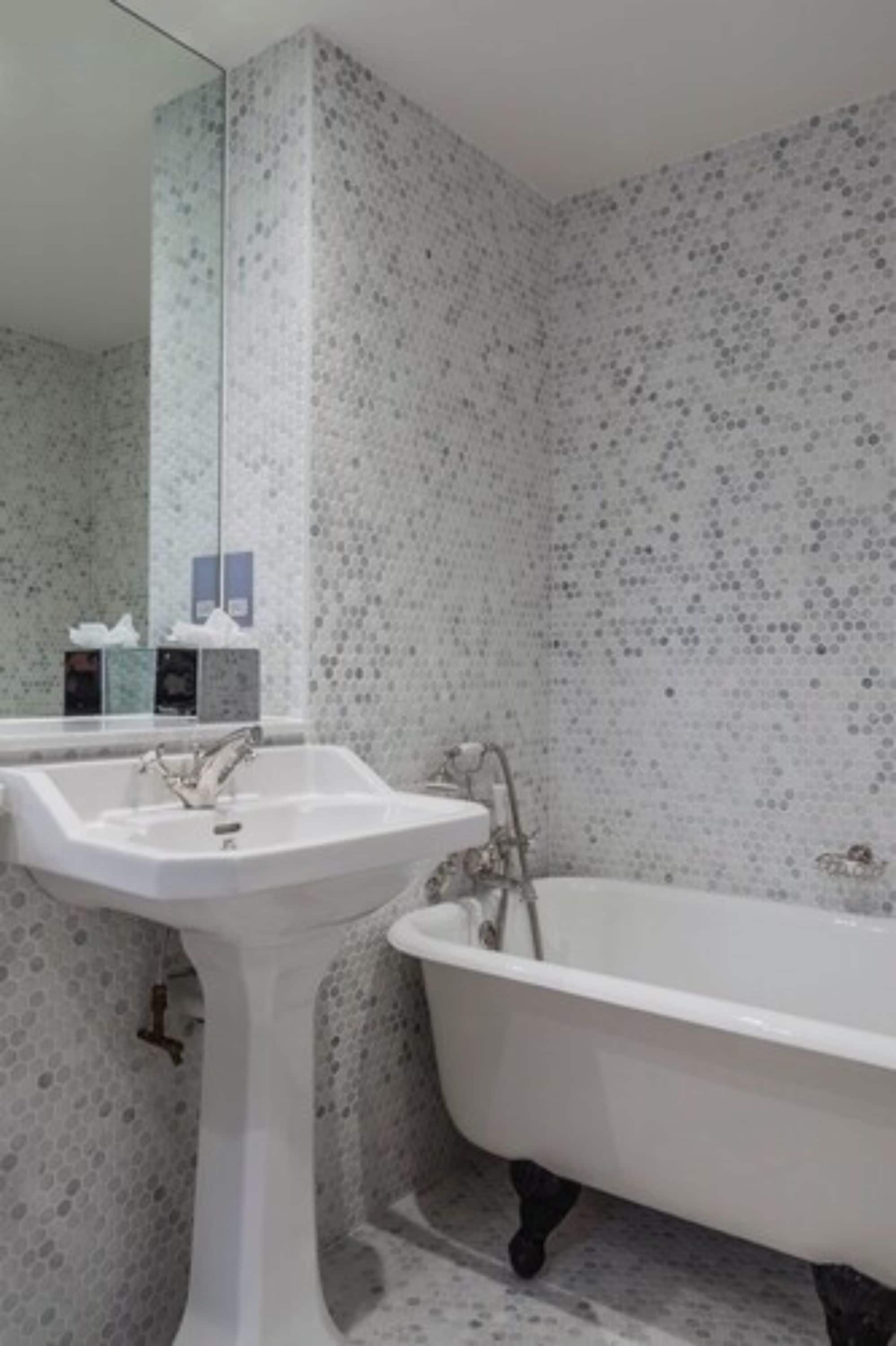 A bathroom with a freestanding sink and a clawfoot bathtub.