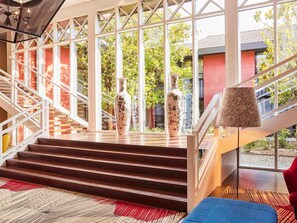 Una escalera con vistas a un edificio rojo y follaje.