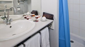 Ein Badezimmer mit einem weißen Waschbecken, einem Spiegel und einem blauen Duschvorhang.