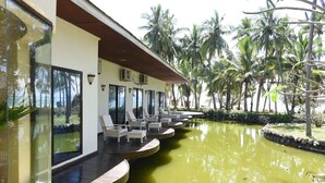 A poolside area with lounge chairs and a view of palm trees. - Diani Reef Beach Resort & Spa - Your Beachfront Bliss Awaits (Diani Beach)