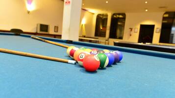 A pool table with a cue stick and numbered balls.