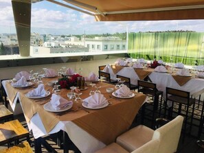 A rooftop dining area with tables set for a meal, overlooking a cityscape. - Hotel Le Pacha (Tunis)