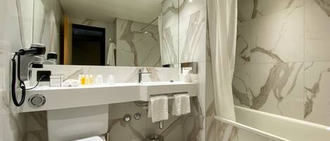 Un baño moderno con inodoro, lavabo y zona de ducha.