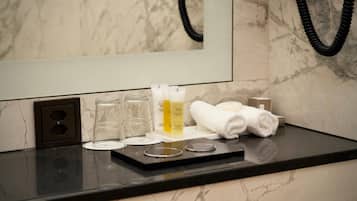 A bathroom counter with toiletries, a towel, and a mirror.