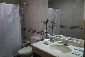 Ein Badezimmer mit Toilette, Waschbecken und Duschbereich.
