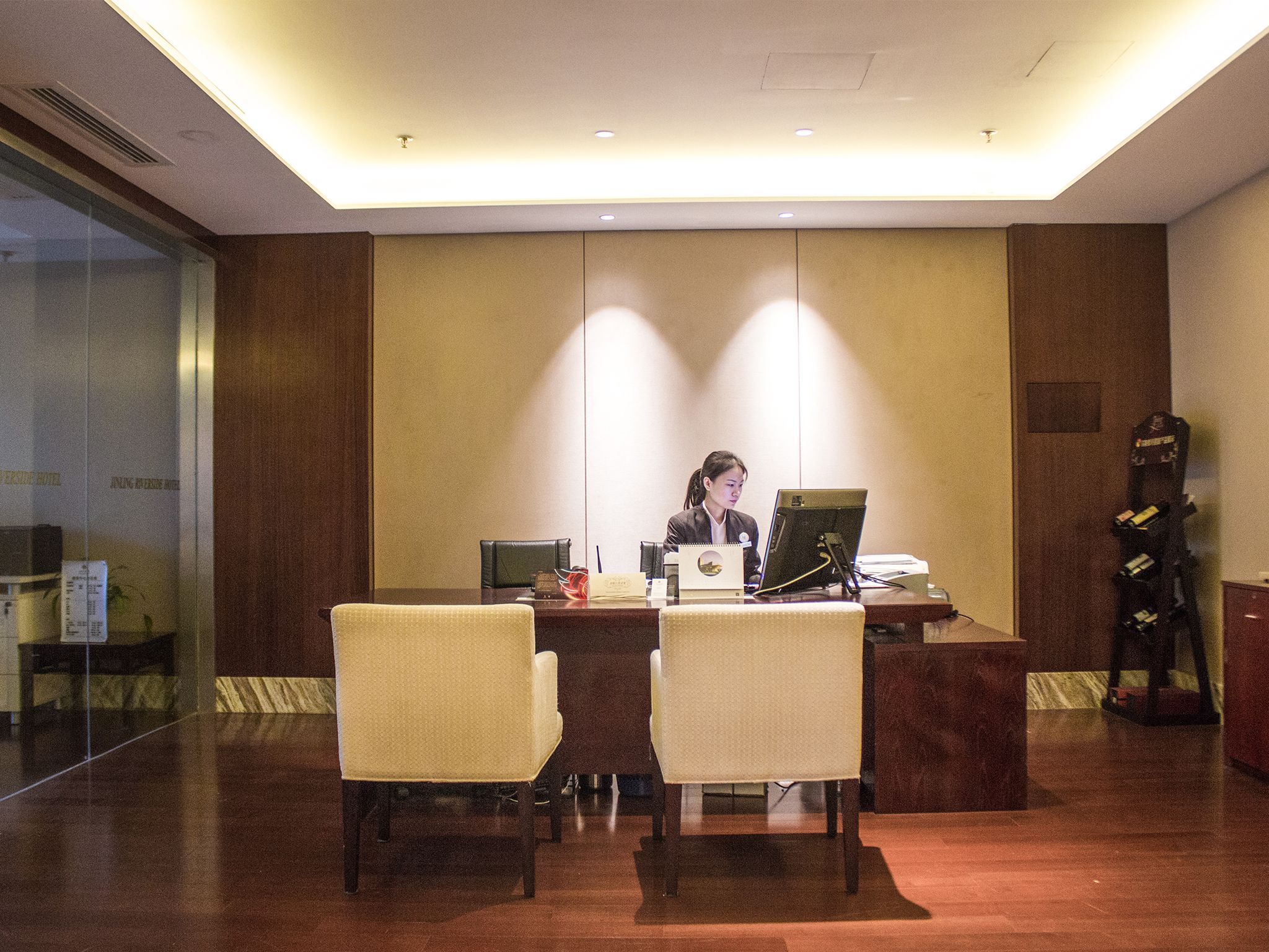 A reception desk with two chairs, a laptop, and a telephone.