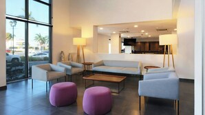 A modern lobby with a sofa set, ottomans, a coffee table, and floor lamps. - City Express by Marriott Tampico (Tampico)