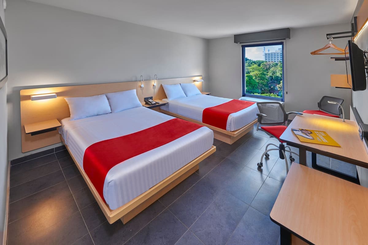 Una habitación de hotel con dos camas, un escritorio, una silla y un televisor.