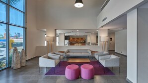 A modern lobby with a seating area, a bar, and large windows. - City Express by Marriott Tampico (Tampico)
