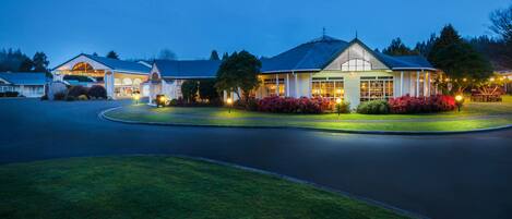 A large, well-lit building with a prominent entrance and a landscaped front yard.