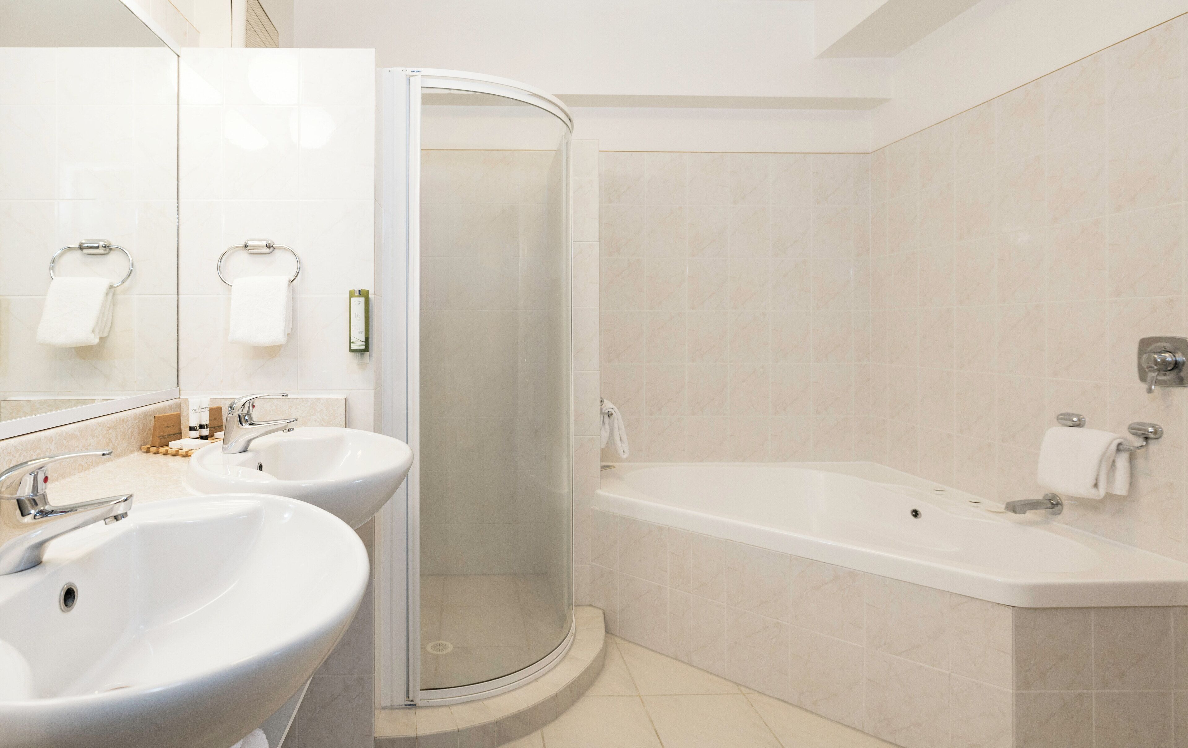 Ein modernes Badezimmer mit zwei Waschbecken, einer Dusche und einer Badewanne.