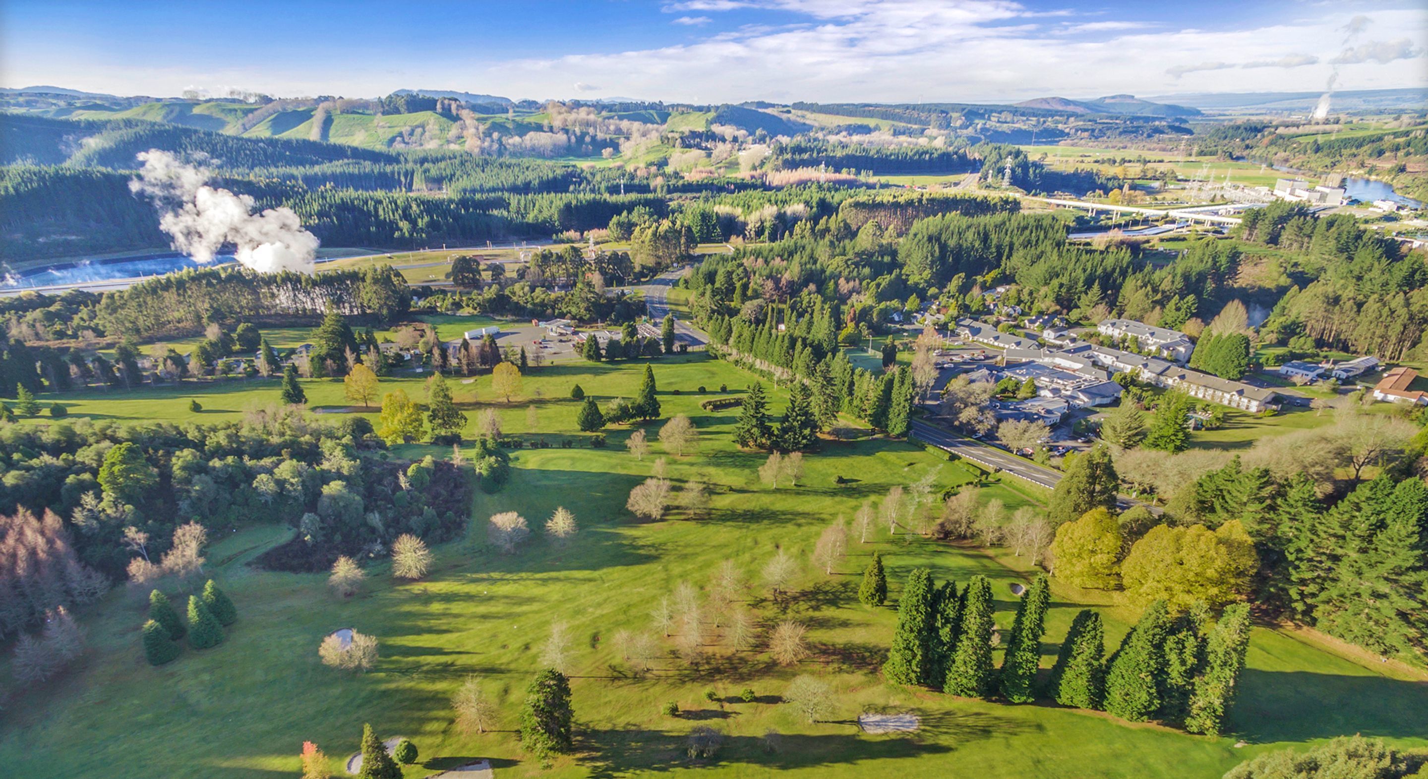Vue aérienne d’un quartier résidentiel avec des maisons, des espaces verts et une étendue d’eau.