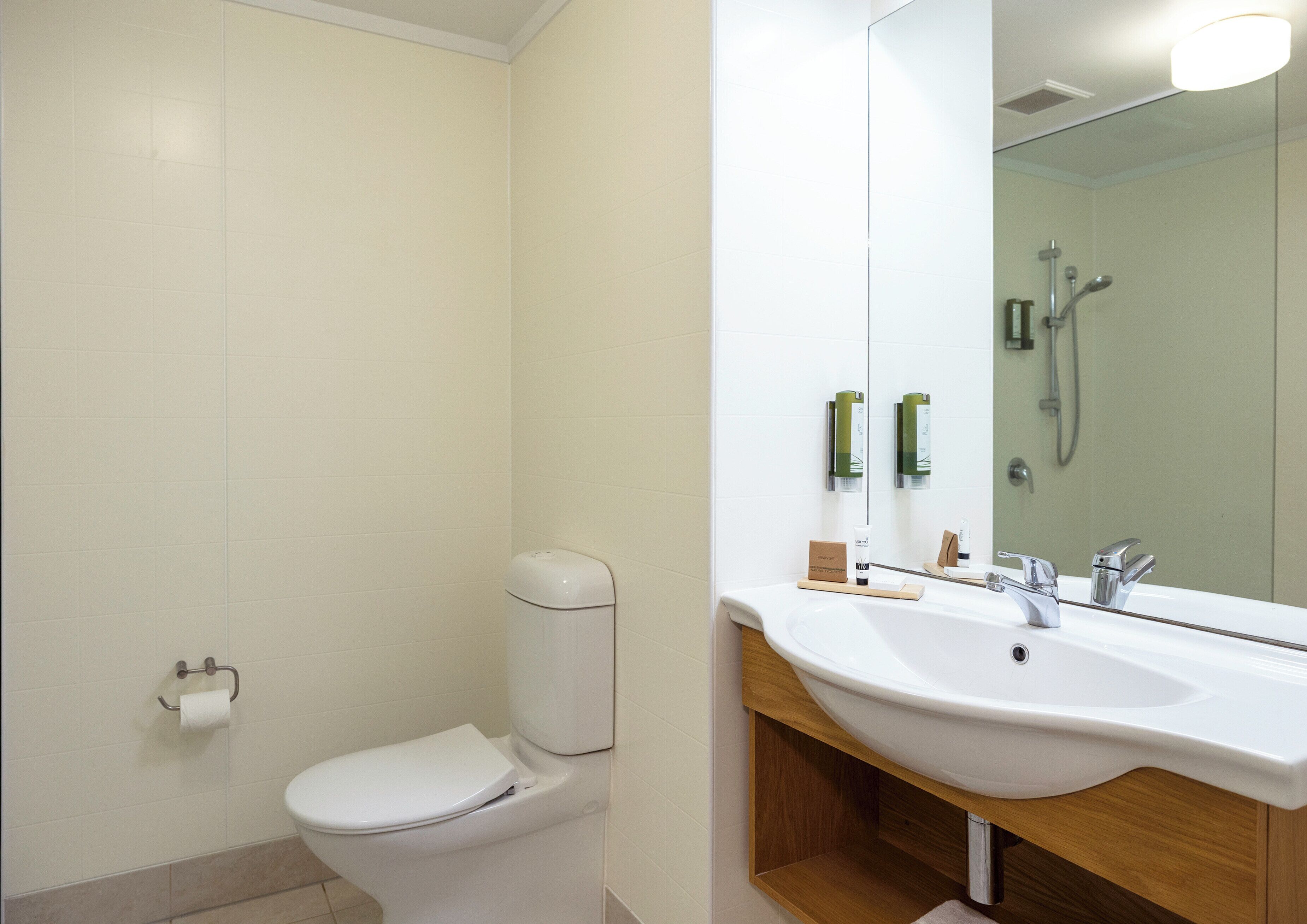A modern bathroom with a toilet, sink, and shower.