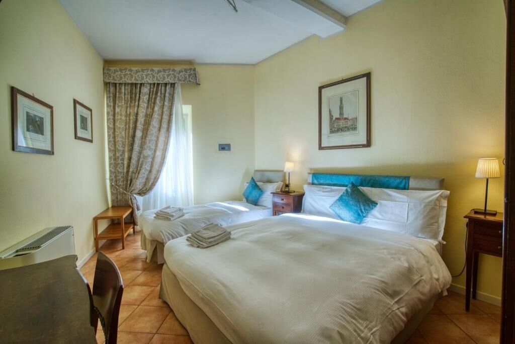 Ein Hotelzimmer mit zwei Betten, einem Schreibtisch und einem Stuhl.